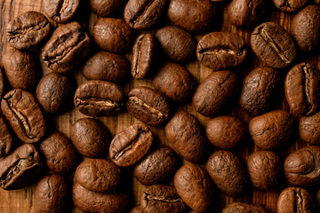 Close-up top view of dark roasted coffee beans on table.