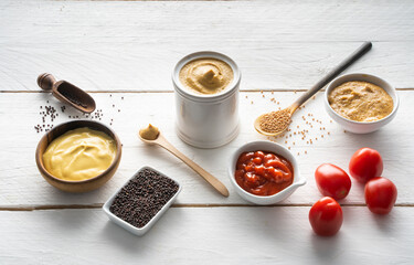 Senf und Ketchup sowie Senfkörner und frische Tomaten
