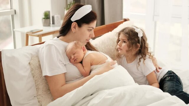 Mother with newborn baby and daughter