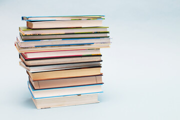 Stack of colorful books on blue background with copy space. Back to school concept.