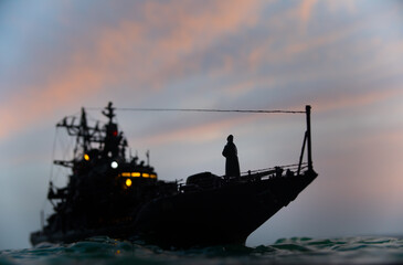 Silhouettes of a crowd standing at blurred military war ship on foggy background. Selective focus.
