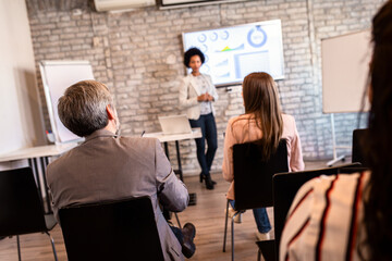 Group of diverse business people in conference meeting room during presentation.