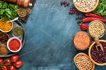 Fototapeta na wymiar Legumes, lentils, chickpea, beans assortment, tasty appetizing ingredients spices grocery for cooking healthy kitchen on black table. Weight loss diet and fight against cholesterol concept. Top view.