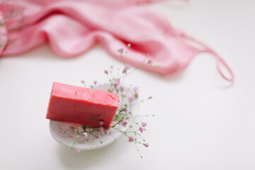 Handmade natural soap on white floral background. Soap making. Soap bars. Spa, skin care. Natural Organic spa cosmetic products on white table from above