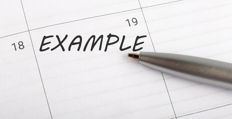Text EXAMPLE on calendar planner to remind you an important appointment with a pen on isolated white background.