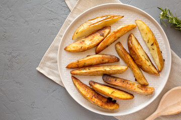 Homemade Rosemary Potato Wedges on a plate, top view. Flat lay, overhead, from above. Space for text.