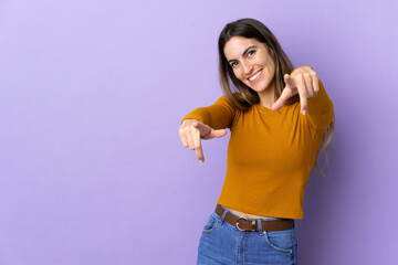 Young caucasian woman over isolated background pointing front with happy expression