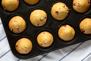Homemade Cranberry Muffins with Orange Zest in a baking pan, top view. Overhead, from above, flat lay.