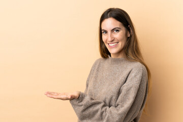 Young caucasian woman over isolated background presenting an idea while looking smiling towards