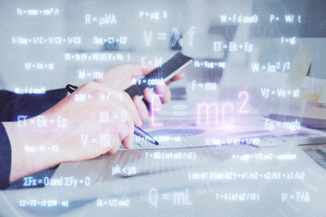 Double exposure of man's hands holding and using a phone and formulas drawing. Education concept.