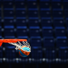 Basketball hoop with a ball on the background of the empty seats of the sports arena