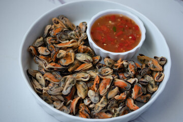Poached mussels with seafood sauce in white plate