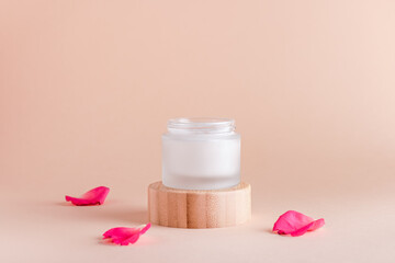 Obraz na płótnie Canvas Facial cream with rose extract and rose petals in minimal still life.