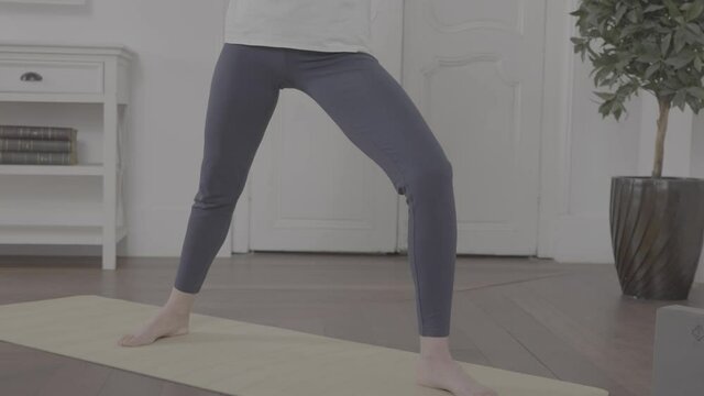 A woman doing some yoga exercises in an apartment