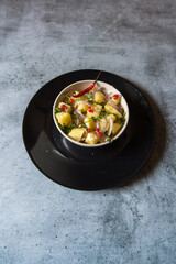 Indian snacks aloo jeera or boiled potatoes mixed with pepper and chopped onions. Top view.