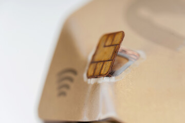 A broken bank credit card with a microchip. A damaged debit card with contactless payment. A...