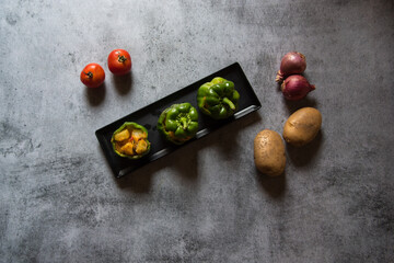 Top view of Stuffed capsicums on a black tray with use of selective focus