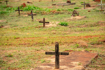 Algumas cruzes sobre túmulos em cemitério.