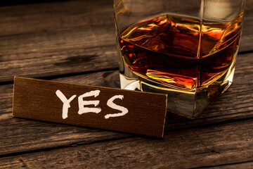 Glass of brandy with the wooden plank on it is an inscription 