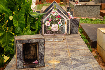 Fototapeta na wymiar Um túmulo com flores em um cemitério.