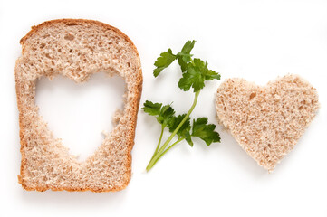 Wheat Bread Slice with cut of hole in the shape of heart and twig parsley