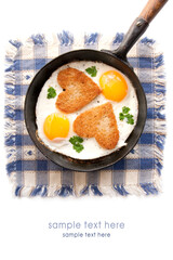 Fried eggs with slices of bread in the shape of a heart in the frying pan