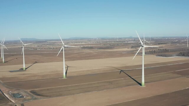 drone side move looking back of a wind turbines in a wind farm from right to left
