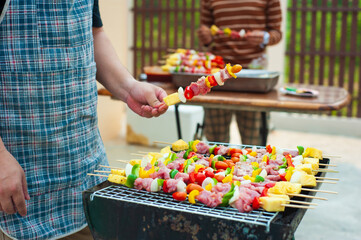 The chef is preparing food and barbecue grilling for the outdoor party at home.