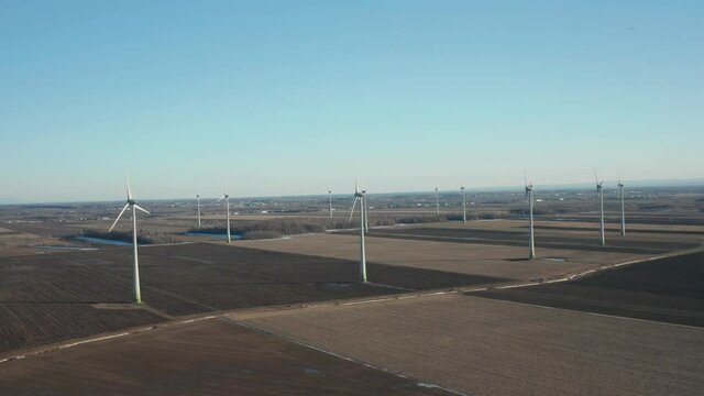 drone going around a big wind farm from far in a sunny day but beginning of winter
great for a big shot