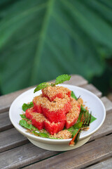 Watermelon. Summer dessert in Thai style of fresh water melon topping with dried crispy fish.