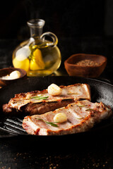 Barbecue ribs with rosemary and garlic on dark background. - 431522925