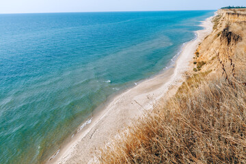 Coastal Clay Cliff and Sandy Beach . Craggy coastline and sunny beach 