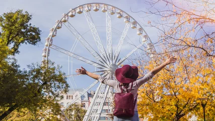 Fototapeten A happy young woman stop near the Budapest Eye big Ferris wheel in Budapest, Hungary © Evgeniya Biriukova