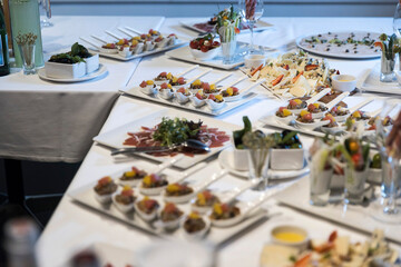 Wedding banquet. A variety of snacks, salads, fish dishes, tartlets on a white tablecloth on table