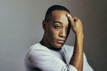 Studio portrait of black African American man hand in forehead looking away