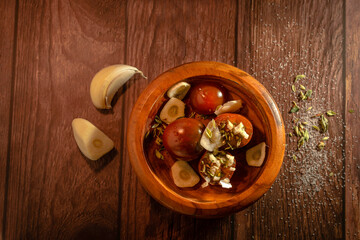 Cherry tomatoes, garlic and parsley on a wooden plate