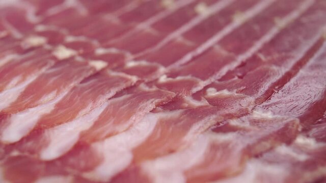 Traditional spanish food jamon. Macro. A fork pierces a cured meat delicacy close-up. Dolly Shot