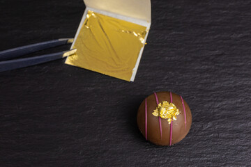 edible gold leaf transfered on a chocolate truffle - 431527508