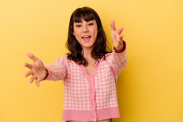 Young caucasian woman isolated on yellow background feels confident giving a hug to the camera.