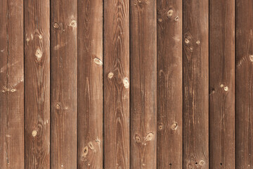 Wooden vertical background with pronounced texture. Brown vertical planks solid wood knots and cracks. The micro-texture of the tree is a pronounced relief.