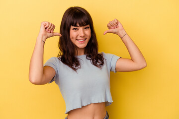 Young caucasian woman isolated on yellow background feels proud and self confident, example to...