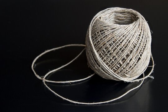A ball of cord made of natural hemp on a black background