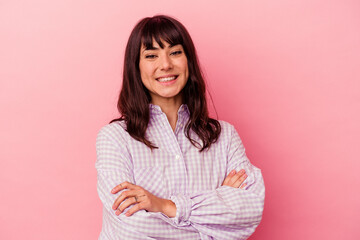 Young caucasian woman isolated on pink background who feels confident, crossing arms with determination.