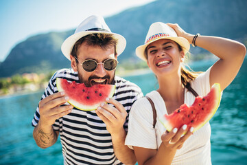 Cheerful couple holding slices of watermelon