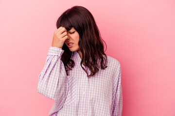 Young caucasian woman isolated on pink background having a head ache, touching front of the face.