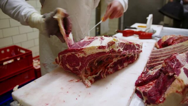 Raw dry aged wagyu entrecote steak cut up as close-up by a butcher on a table
