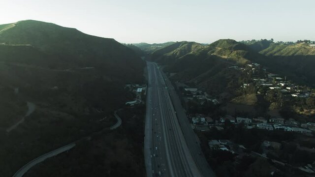 Aerial Shot Of Traffic On Highway By Near Famous Getty Center, Drone Flying Forward Over Vehicles Against Sky At Sunset - Los Angeles, California