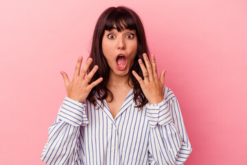 Young caucasian woman isolated on pink background showing number ten with hands.