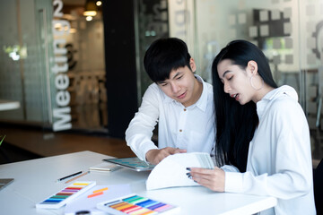 Obraz premium Asian designers man are sharing ideas with customer for the interior using a tablet at the office.