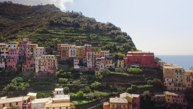 Spectacular seaside landscape in Cinque Terre during summer. Hinterland and coast cover of colored houses in mountain slope and cliff.Blue sea and sky in a sunny journey